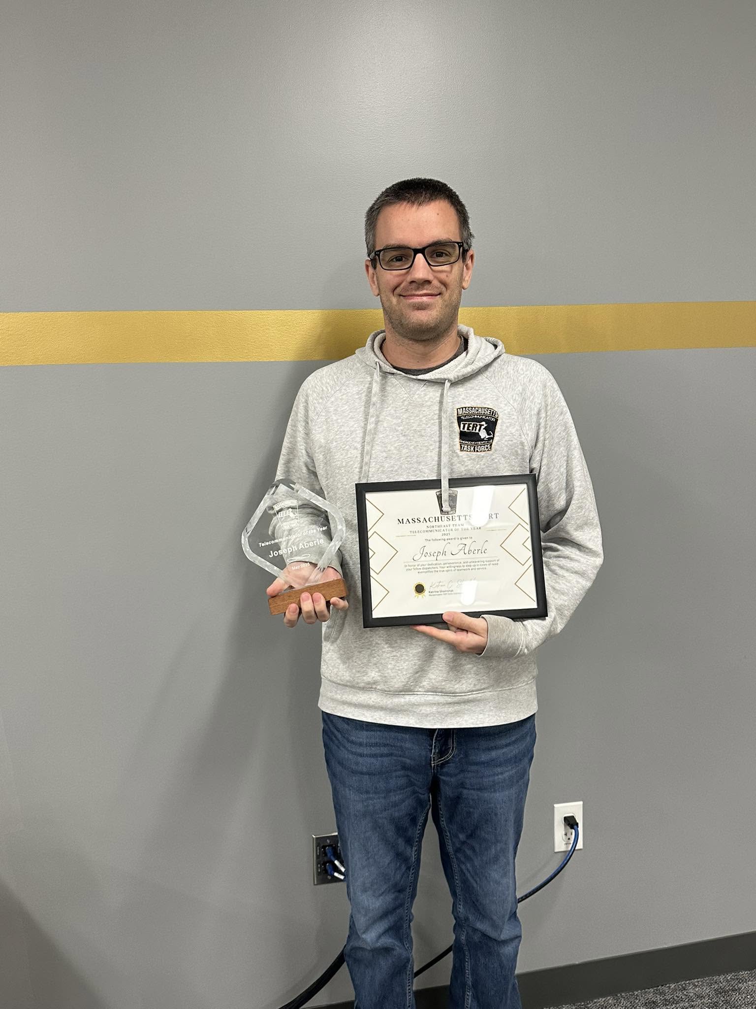 Joey Aberle holding telecommunicator awards